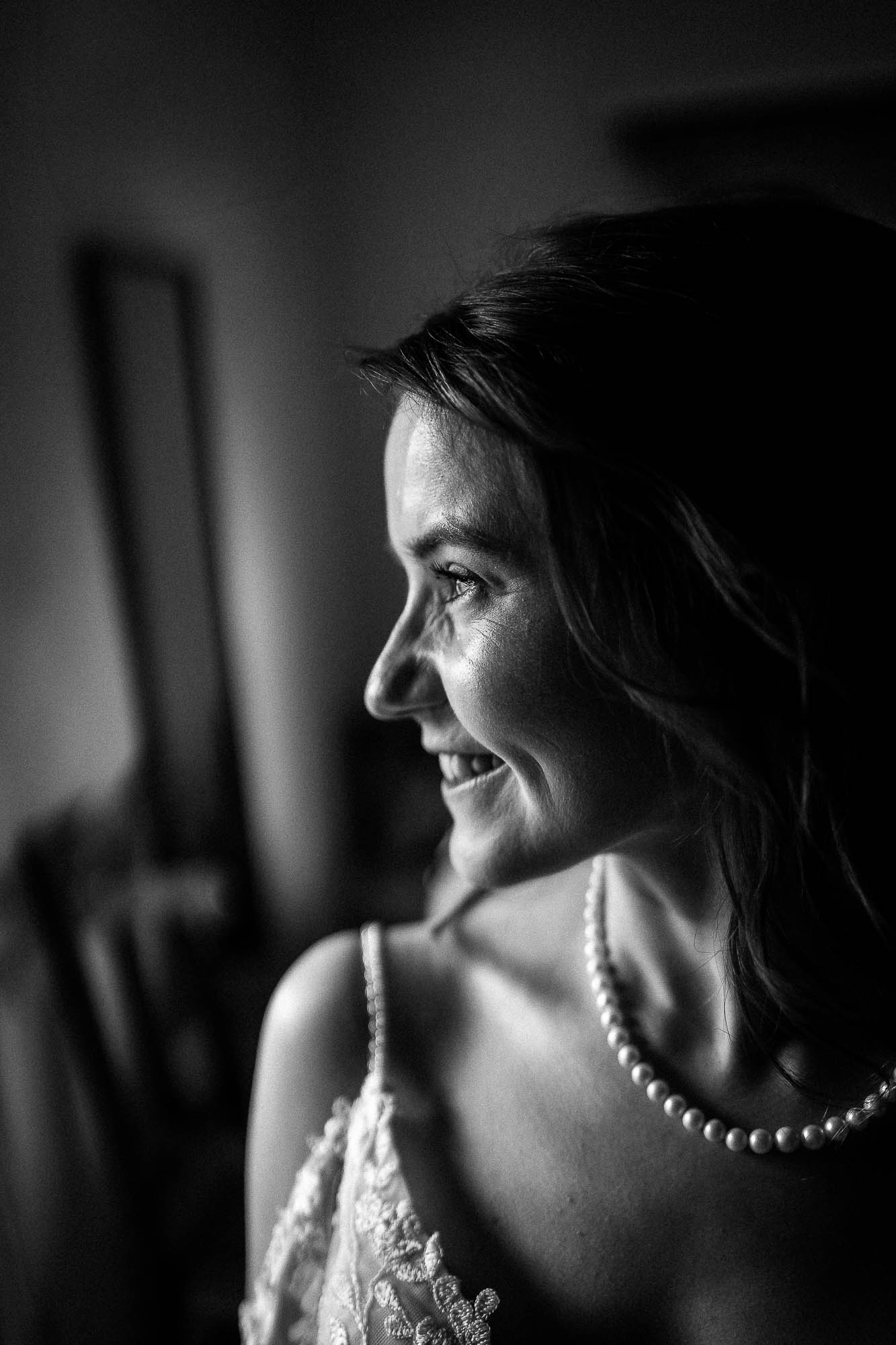 Bride smiling in soft side profile portrait during bridal preparations at Wonwood Barton