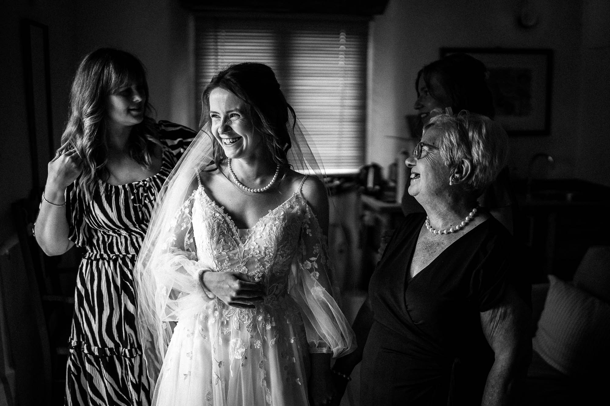 Bride laughing with bridesmaids during relaxed bridal preparations at Wonwood Barton wedding