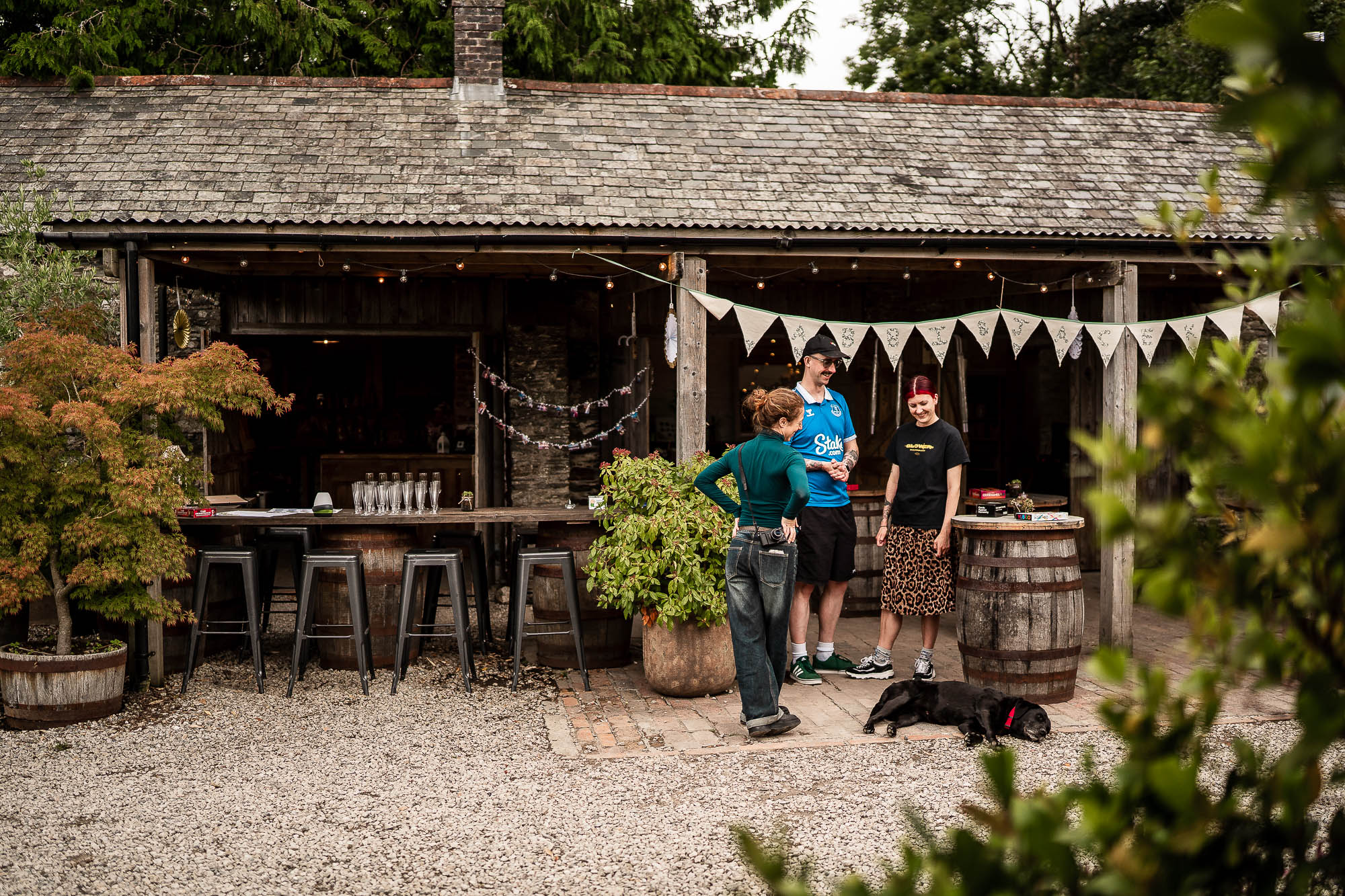 Guests chatting outside rustic stone barn courtyard at Wonwood Barton wedding venue