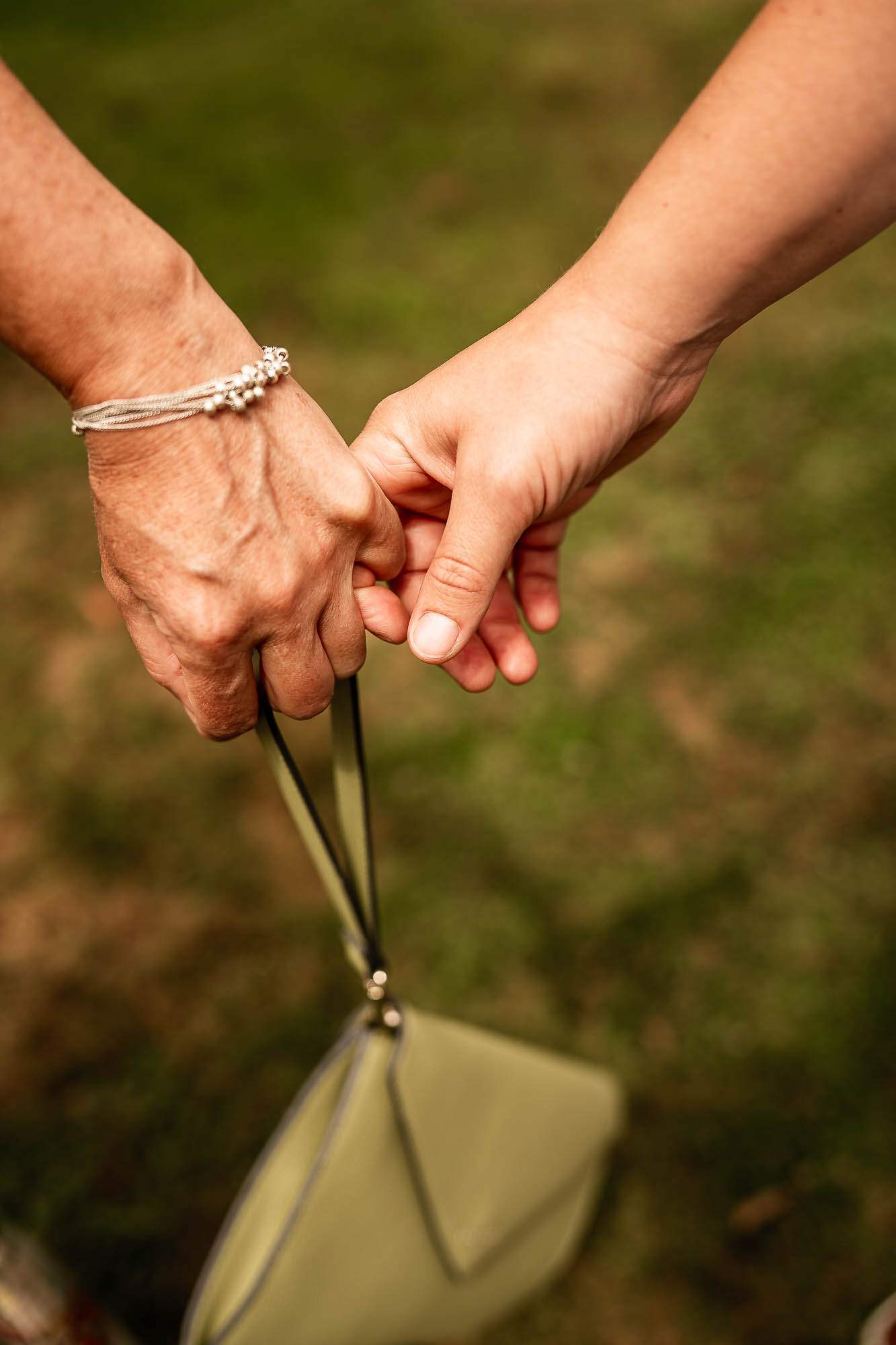 Close up of couple holding hands during outdoor wedding ceremony in Devon countryside