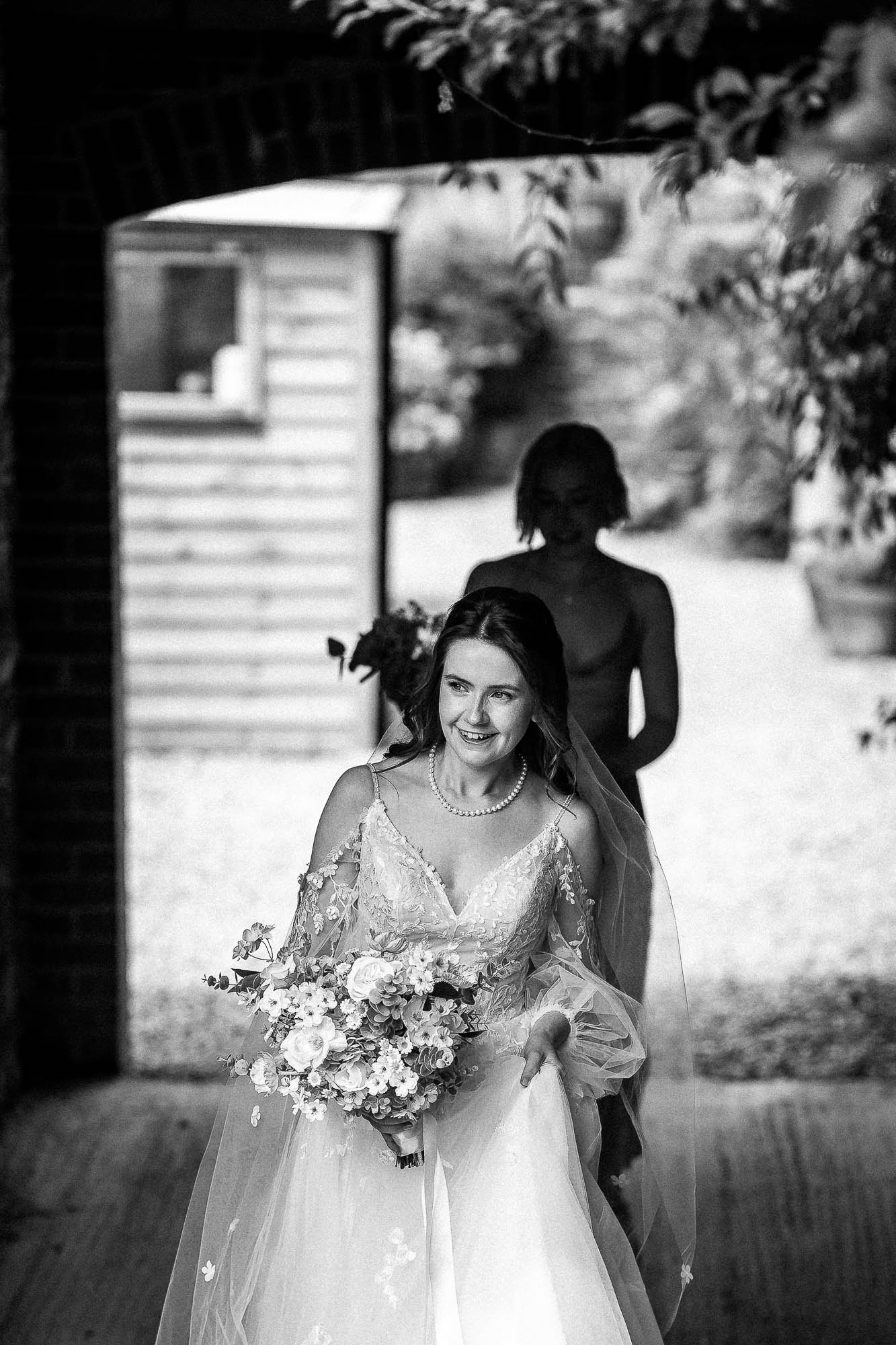 Black and white bridal entrance through barn doorway at Wonwood Barton wedding