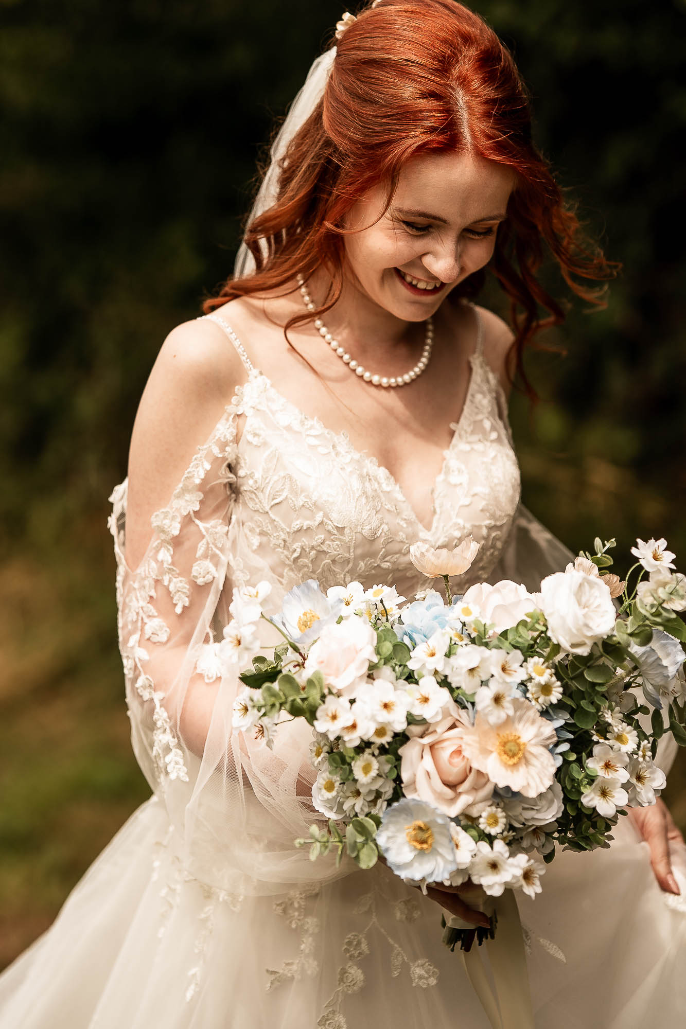 ed haired bride holding bouquet in soft natural light at Wonwood Barton wedding venue