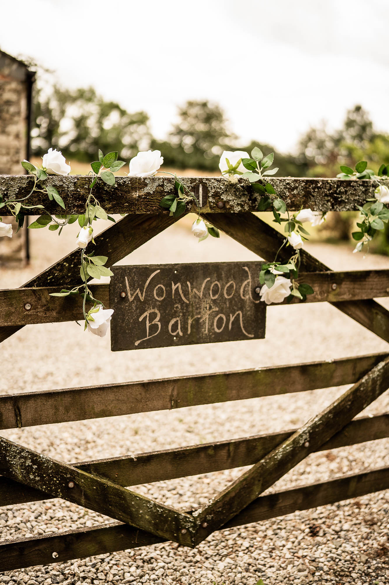 Floral decorated wooden gate entrance at Wonwood Barton wedding venue Devon