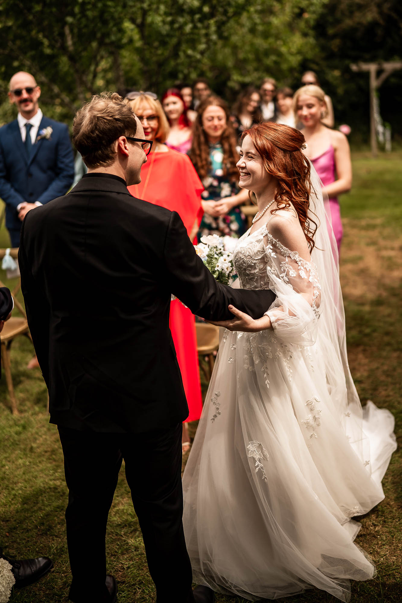 Bride and groom smiling at each other during outdoor wedding ceremony in Devon