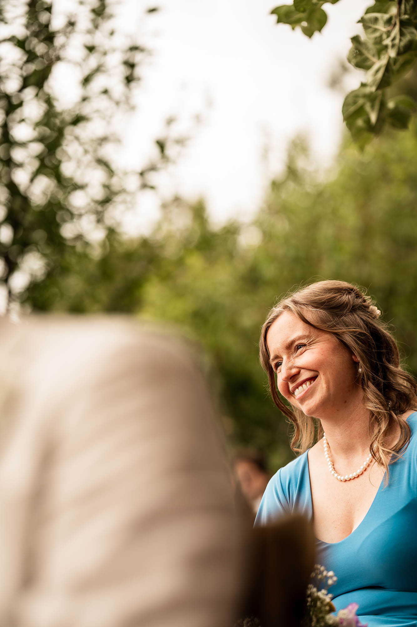 Bridesmaid smiling during outdoor ceremony at Wonwood Barton, Devon wedding venue