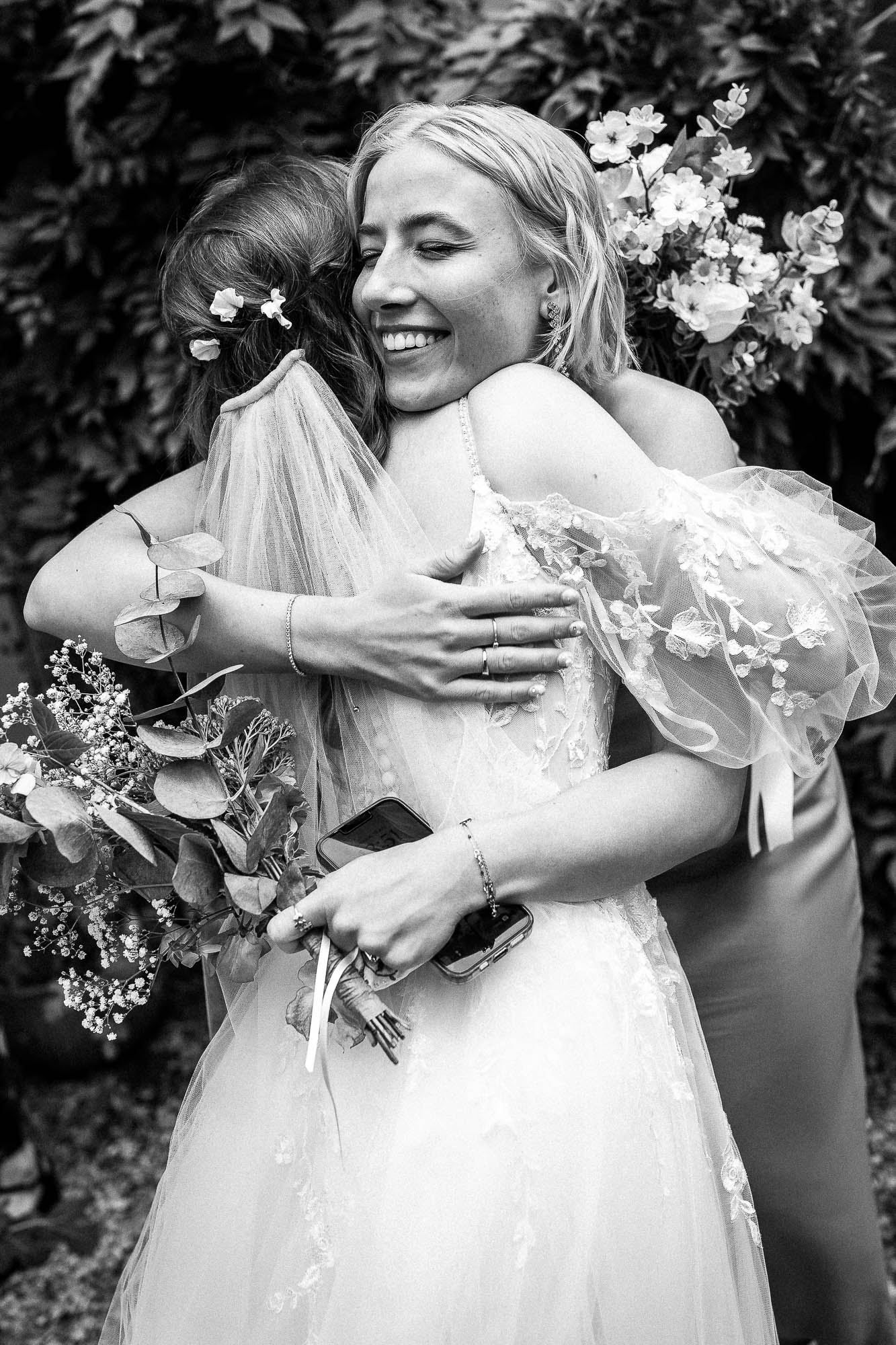 Bride hugging close friend during outdoor drinks reception at Wonwood Barton