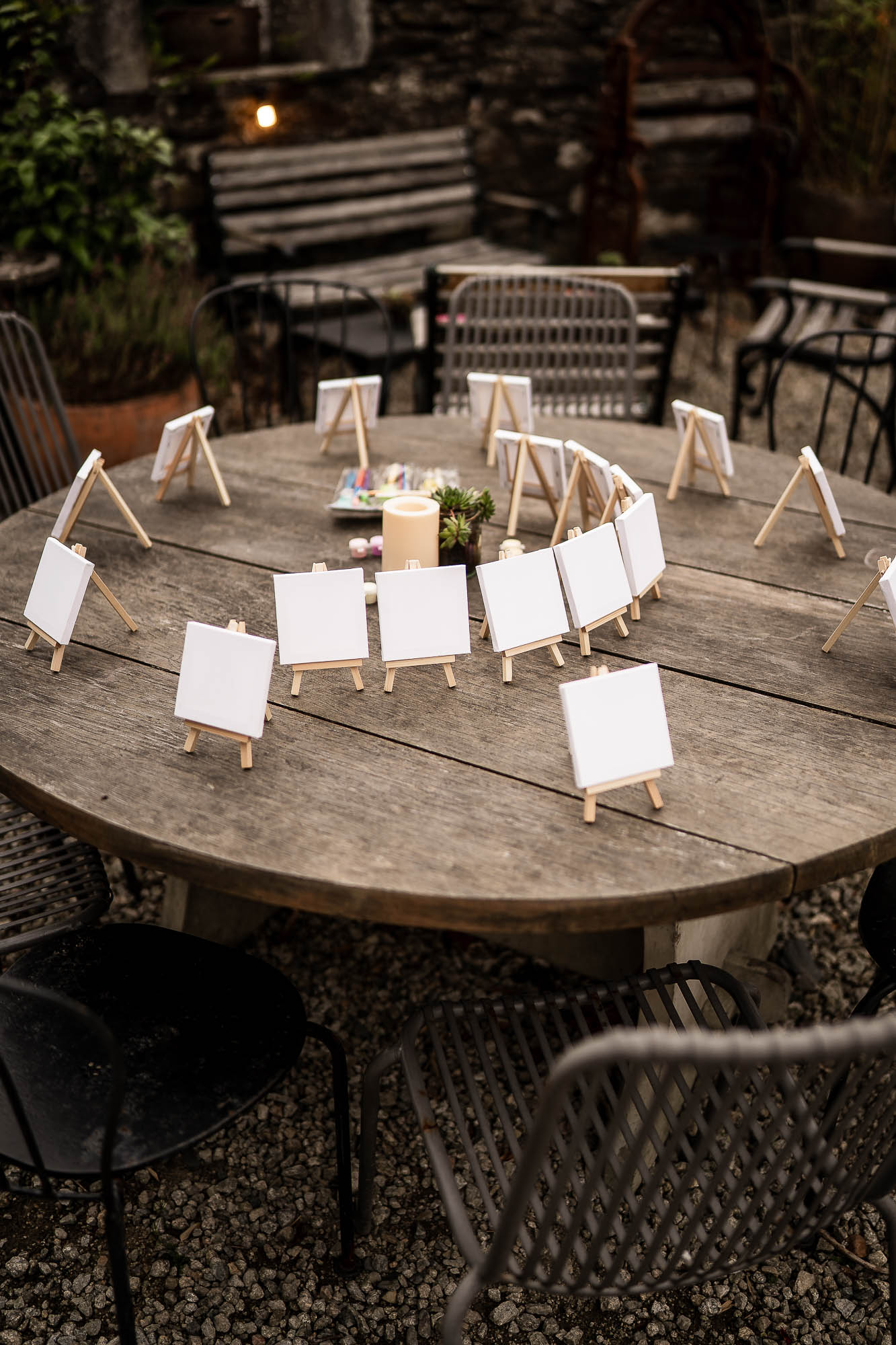 Mini easels set up for wedding table names in rustic courtyard setting
