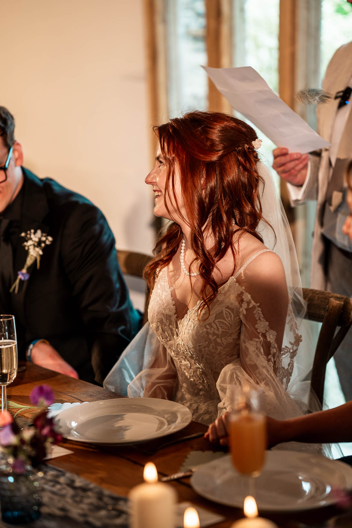 Bride smiling during wedding breakfast speech at Wonwood Barton barn in Devon