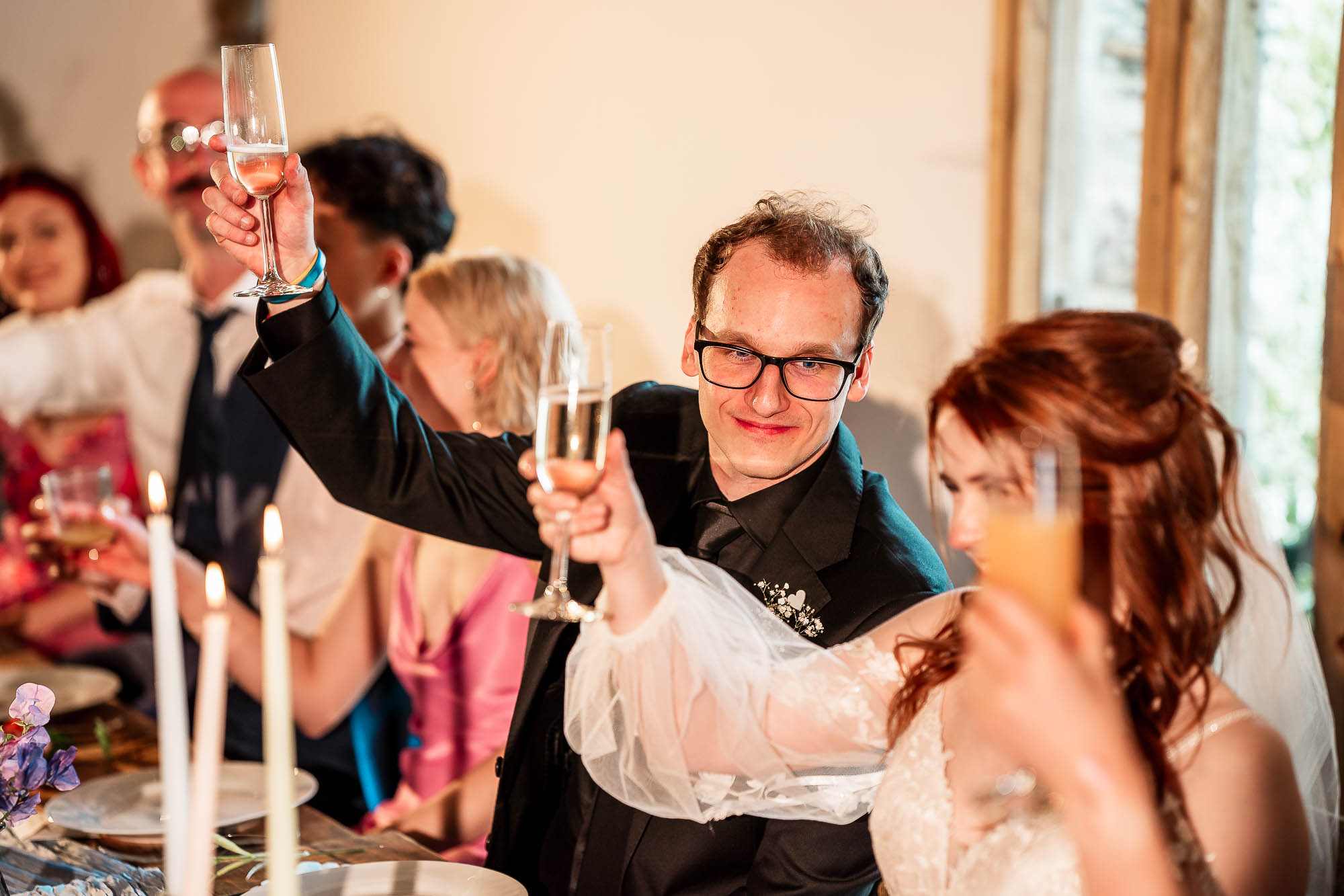 Bride and Groom raising champagne glass for toast during wedding breakfast at Wonwood Barton Devon
