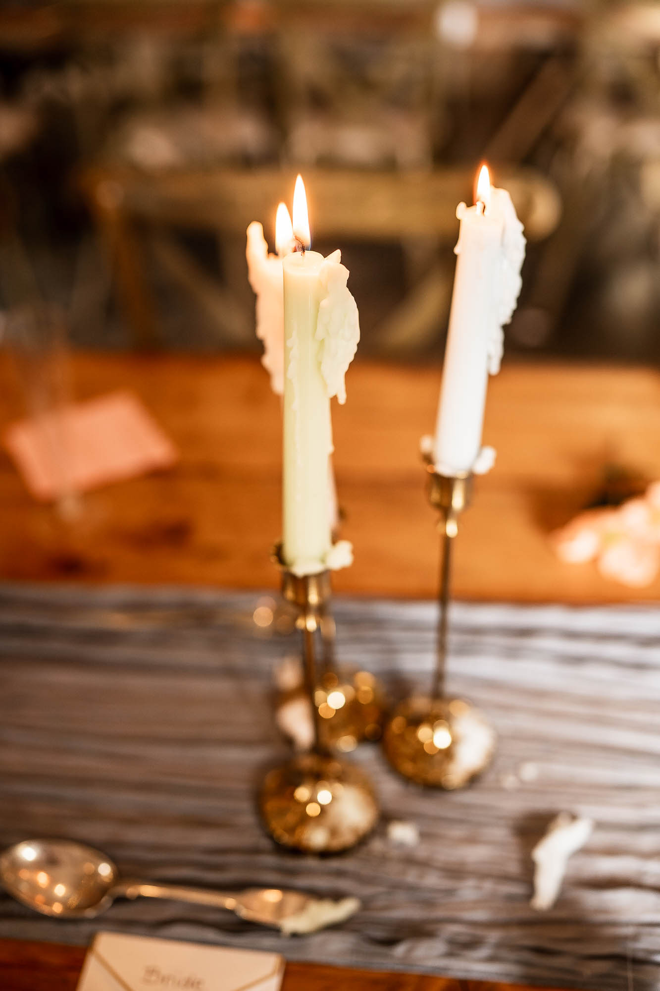 Lit taper candles on rustic wooden wedding breakfast table at Wonwood Barton