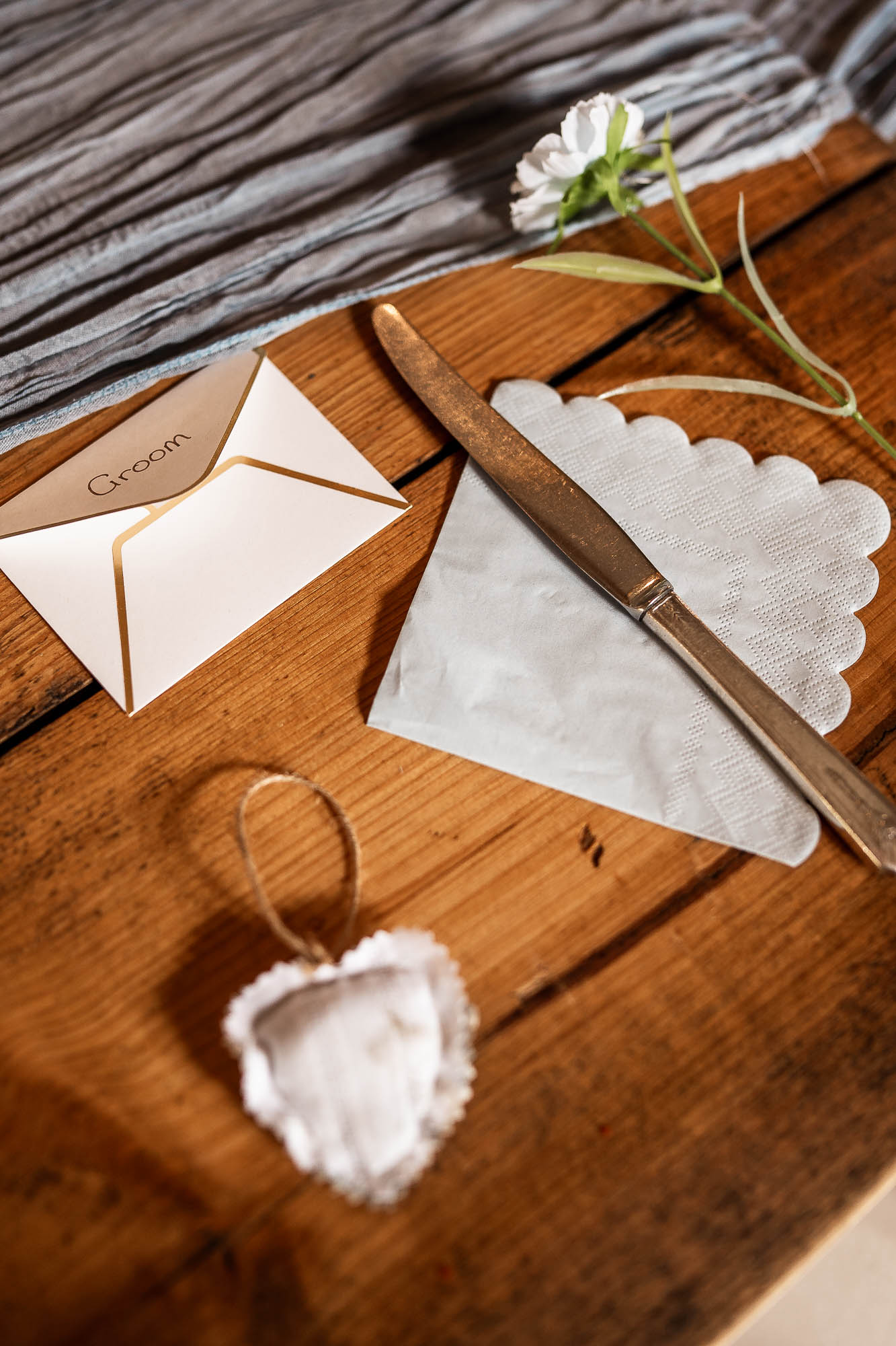 Wedding place setting with groom name card on rustic table at Wonwood Barton