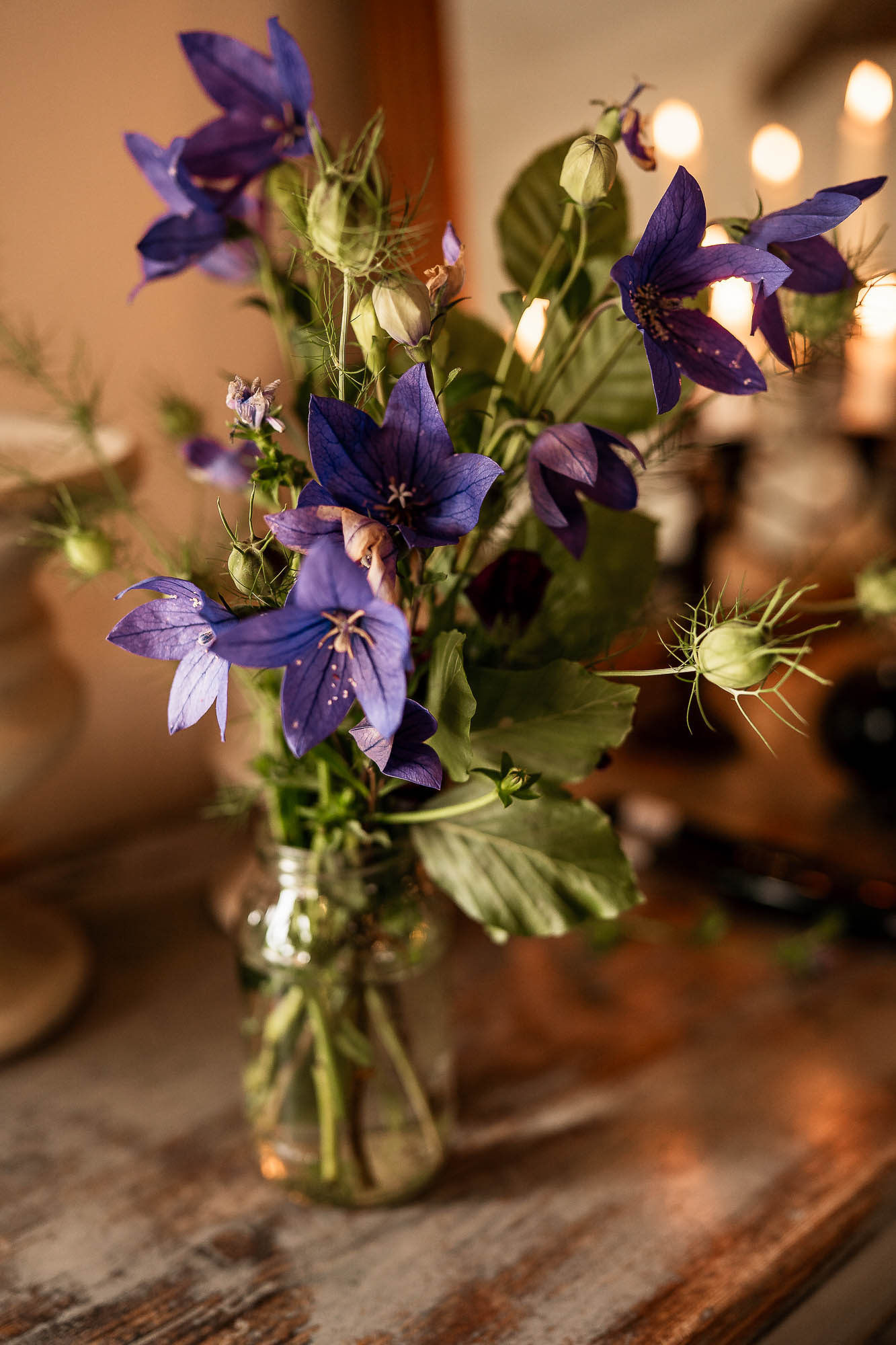 Purple and wildflower wedding centrepiece in mason jar at Wonwood Barton reception