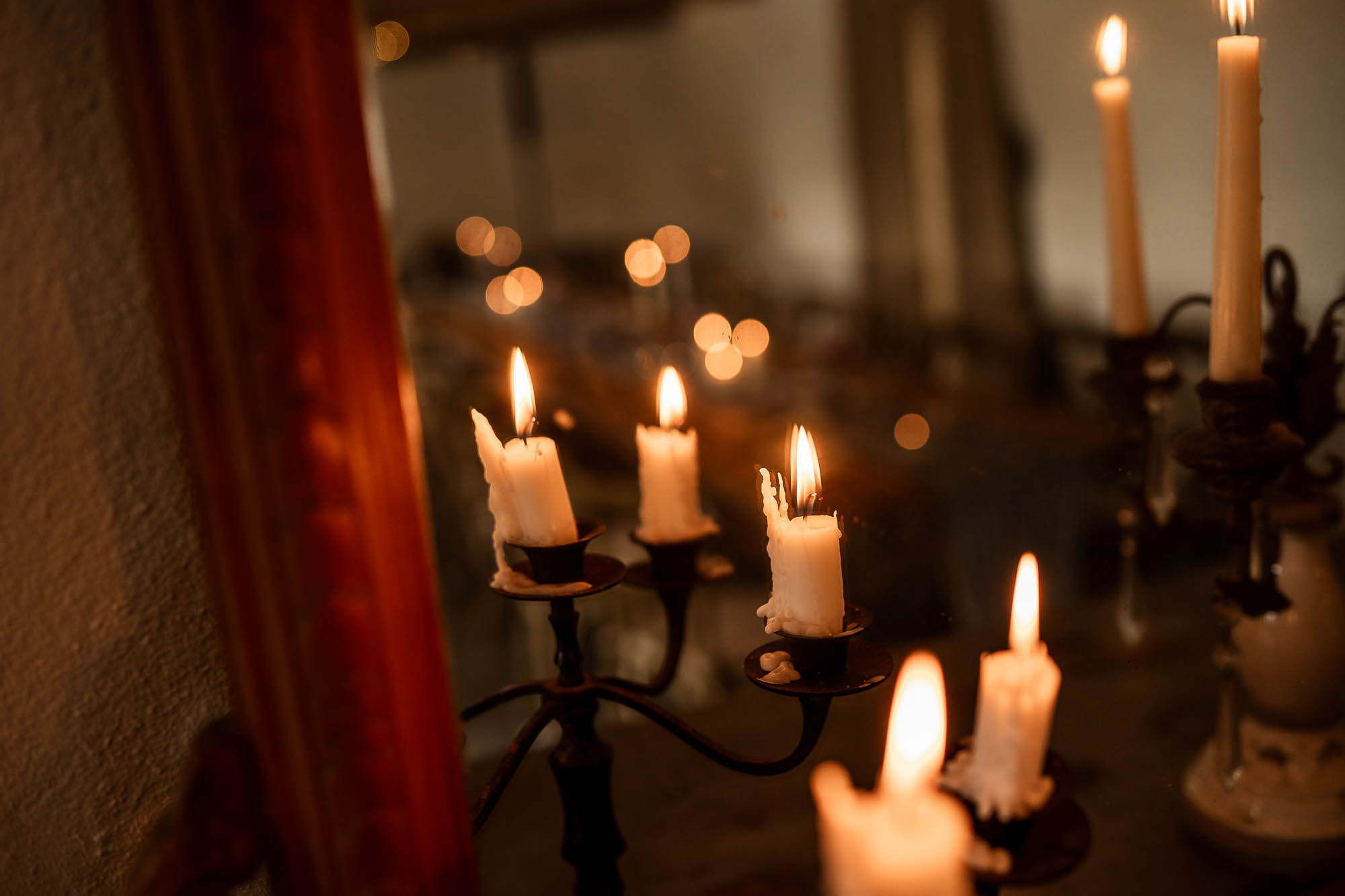 Close-up of lit taper candles during evening reception at Wonwood Barton in Devon