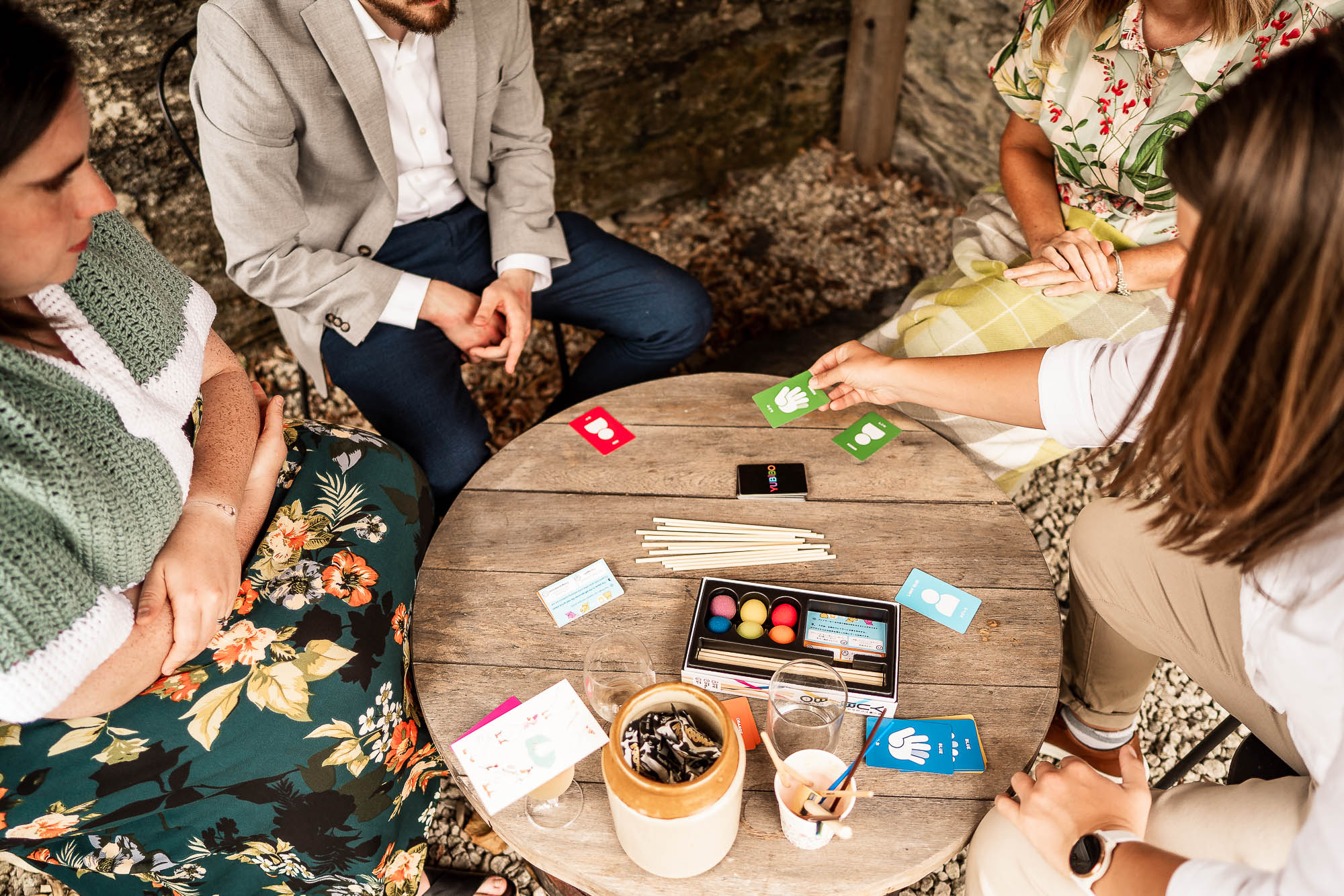 Wedding guests playing card game during outdoor drinks reception at Wonwood Barton