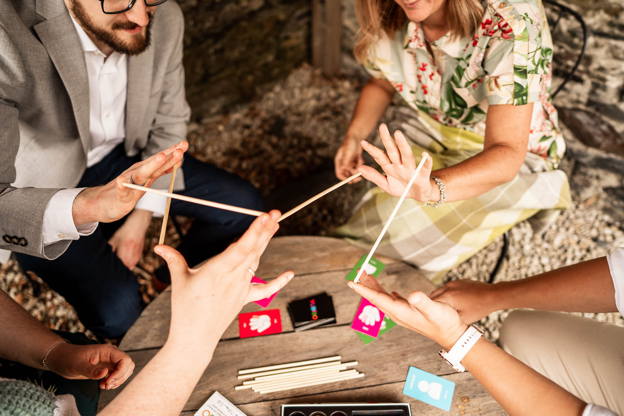 Wedding guests playing traditional stick game at Wonwood Barton drinks reception in Devon