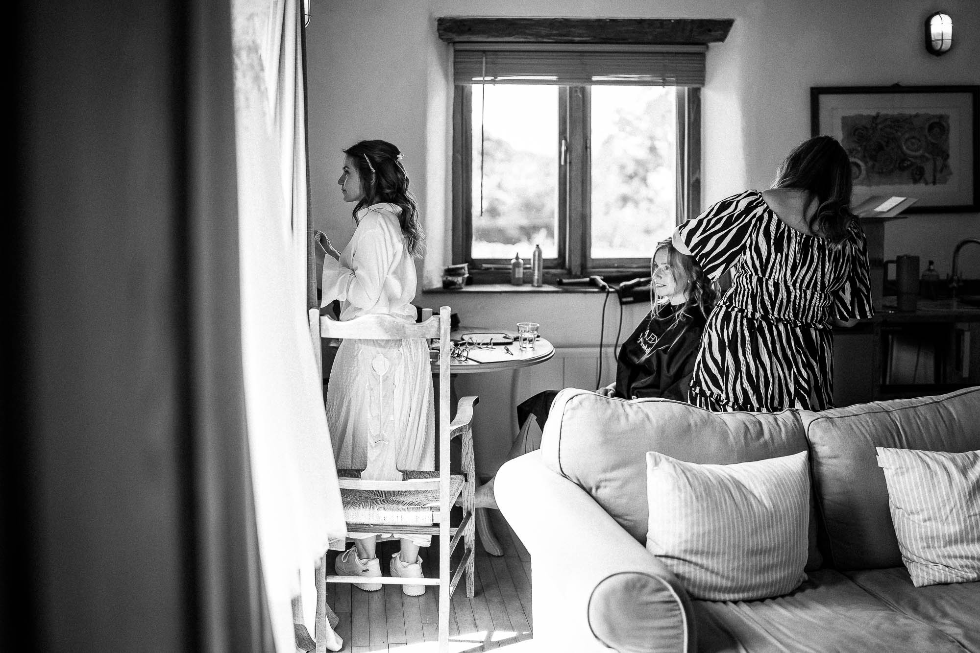 Bride getting ready with hair and makeup in natural window light