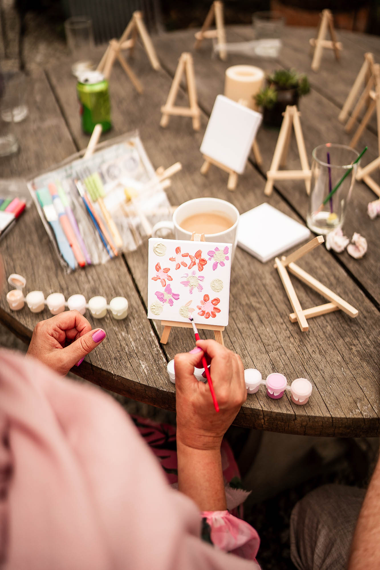 Wedding guest painting mini canvas during drinks reception at Wonwood Barton in Devon