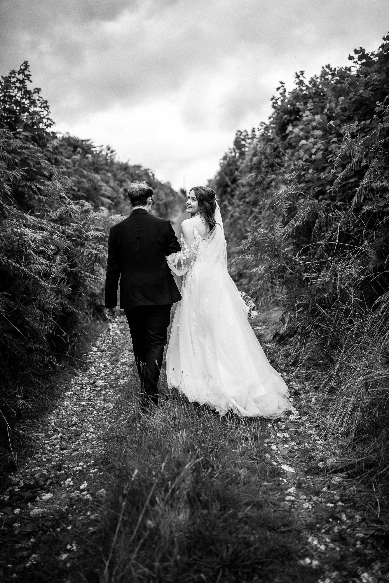 Bride and groom walking along country lane at Wonwood Barton wedding in Devon
