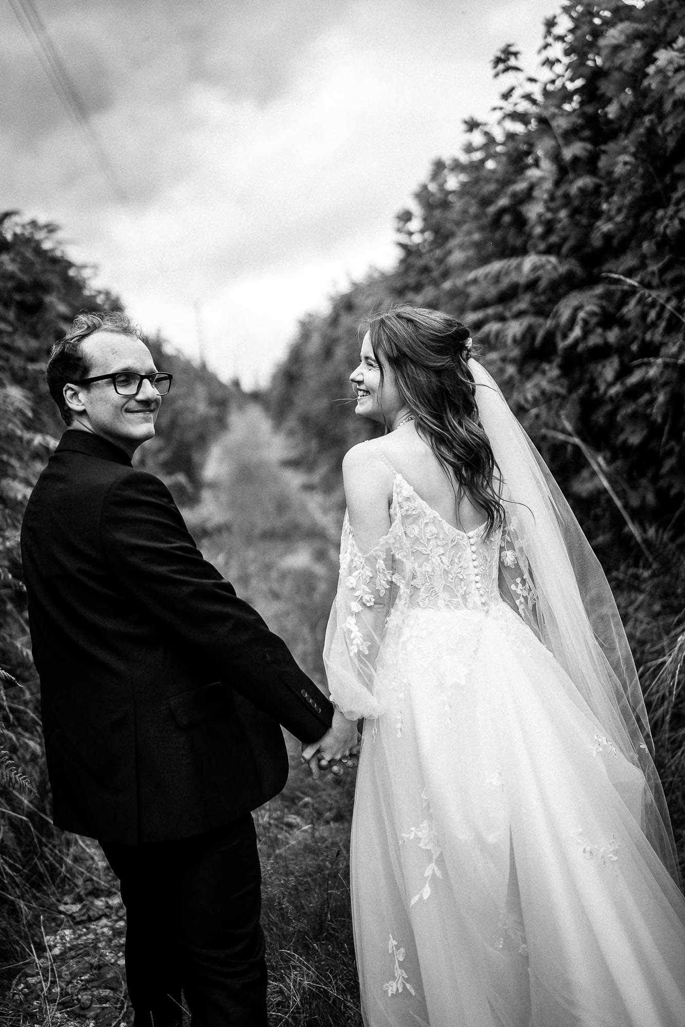 Bride and groom holding hands on country path at Wonwood Barton in Devon