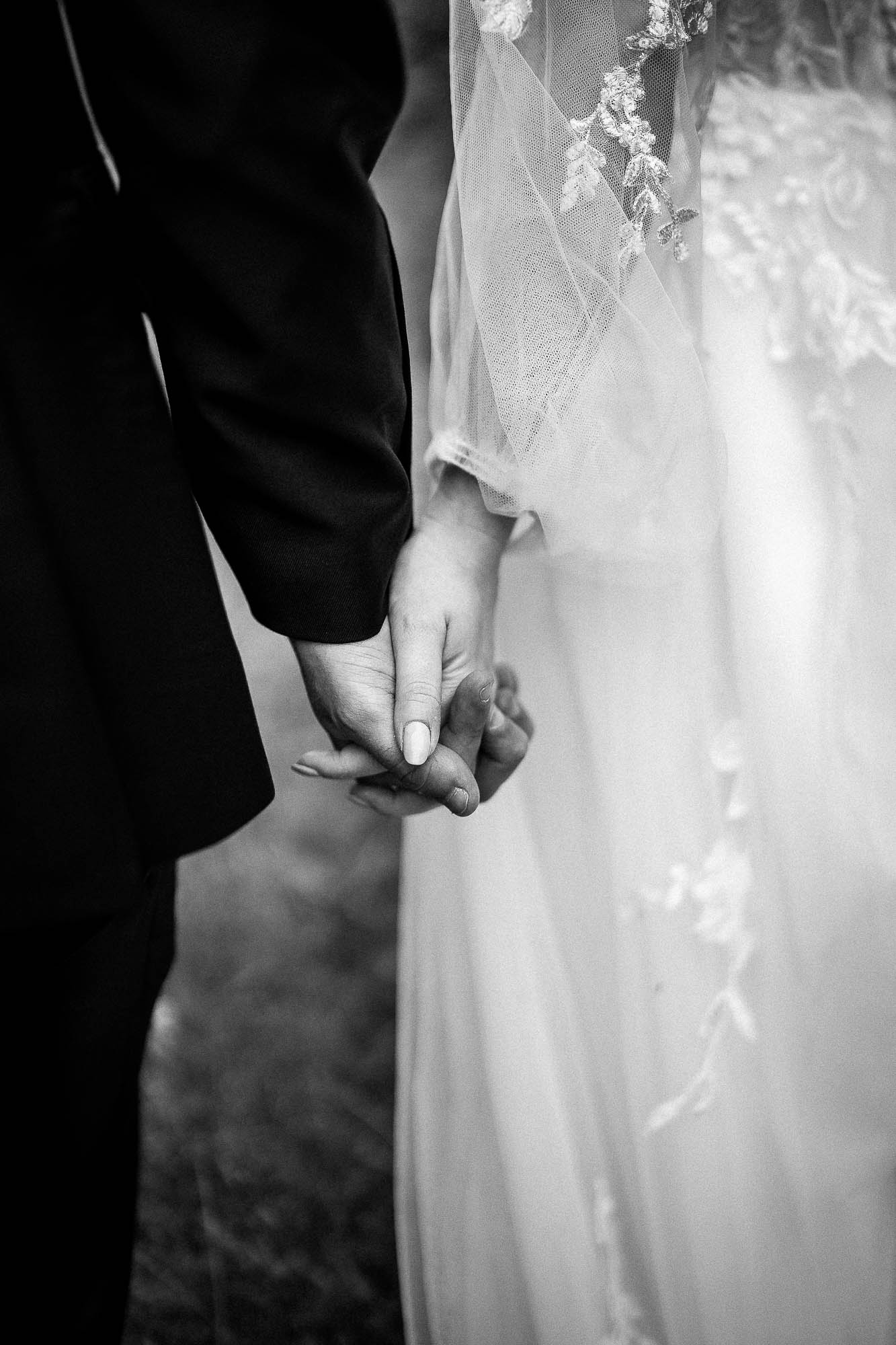 Close-up of bride and groom holding hands during Wonwood Barton wedding