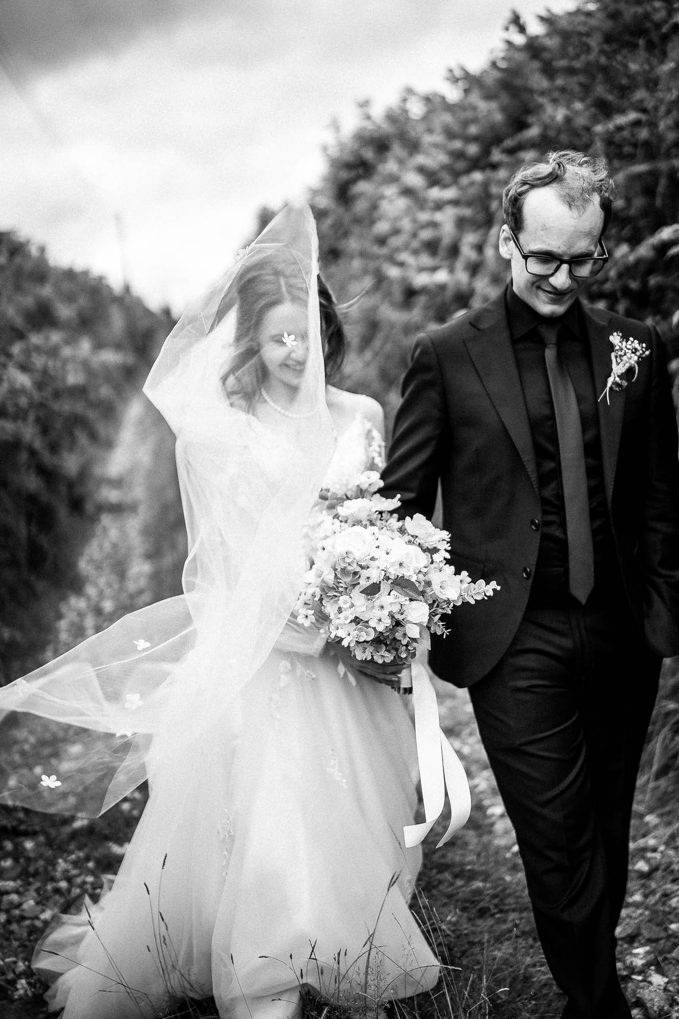 Bride and groom walking with veil blowing at Wonwood Barton countryside wedding